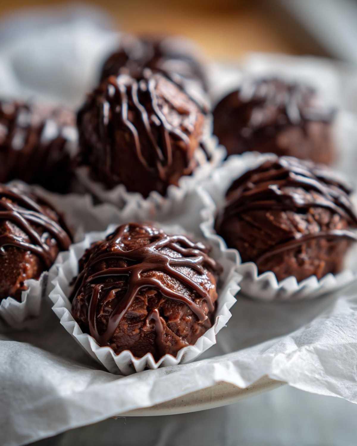 Close-up of rich, fudgy Keto Chocolate Peanut Butter Fat Bombs drizzled with melted chocolate.