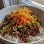 A close-up of Korean Ground Beef Bulgogi Bowls featuring savory ground beef over white rice, topped with shredded carrots and green onions.