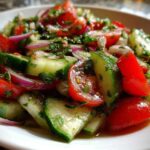 Close-up of fresh Mediterranean Cucumber Tomato Salad featuring chopped tomatoes, cucumbers, and red onion.