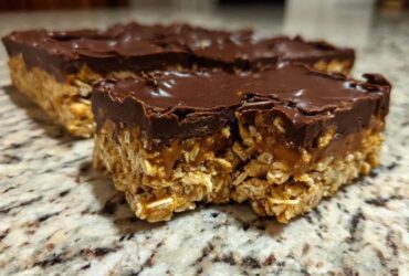 Close-up of a thick No-Bake Chocolate Peanut Butter Oat Bars slice showing the oat base and chocolate topping.