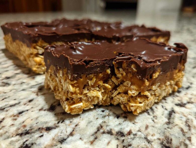Close-up of a thick No-Bake Chocolate Peanut Butter Oat Bars slice showing the oat base and chocolate topping.