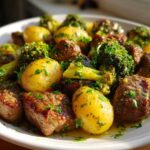 Close-up of One-Pan Garlic Butter Steak Bites and Potatoes mixed with broccoli florets, drizzled with garlic butter sauce.