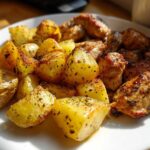 Close-up of golden roasted potatoes and seasoned chicken pieces from Sheet Pan Lemon Pepper Chicken and Potatoes.
