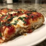 Close-up of a thick slice of Gluten-Free Margherita Pizza showing crust, melted mozzarella, tomato sauce, and fresh basil.