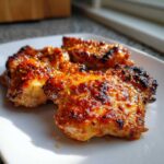 Close-up of three pieces of Spicy Honey Garlic Air Fryer Chicken Thighs with a sticky, caramelized glaze.
