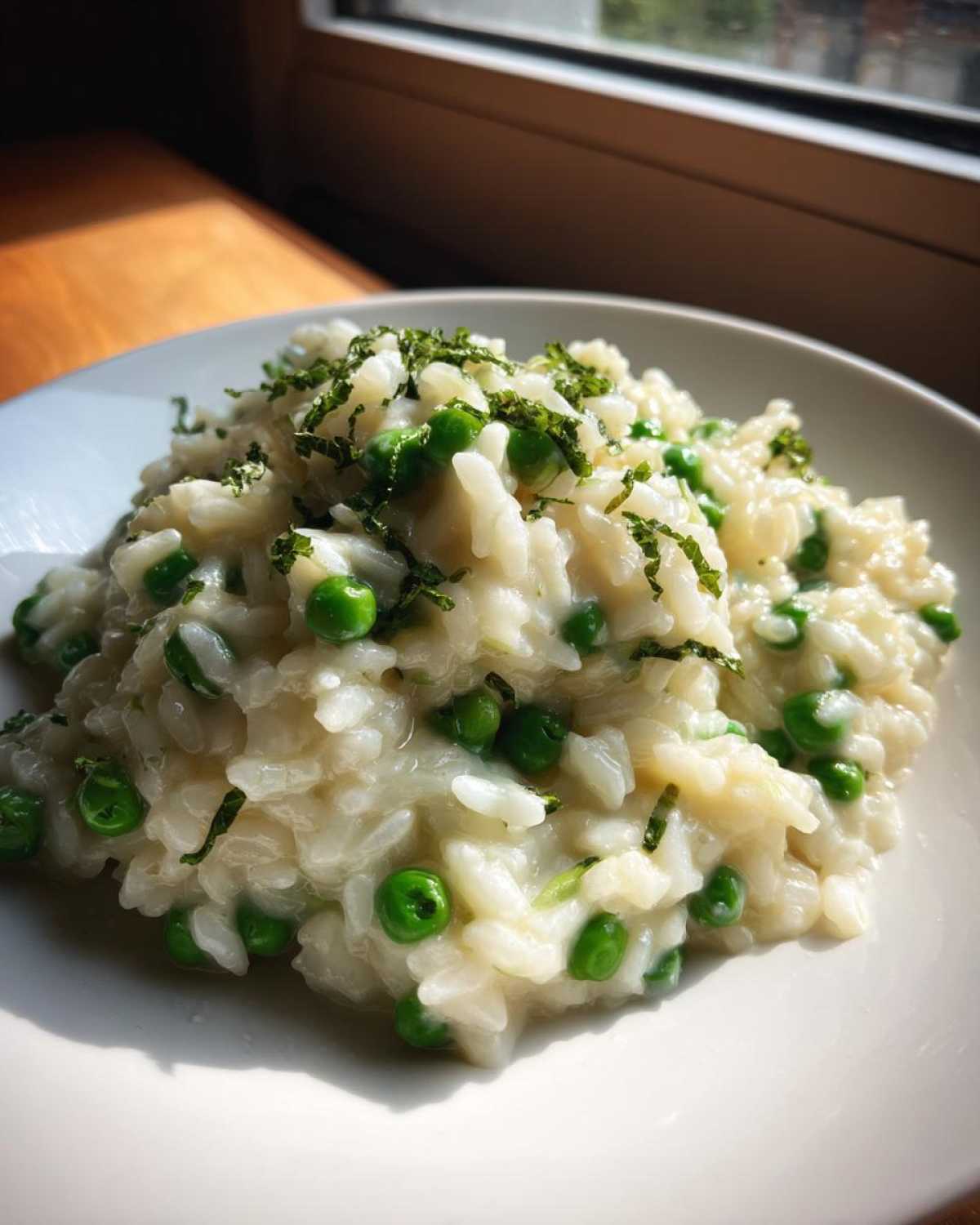 A close-up of creamy Spring Pea and Mint Risotto topped with fresh chopped mint.