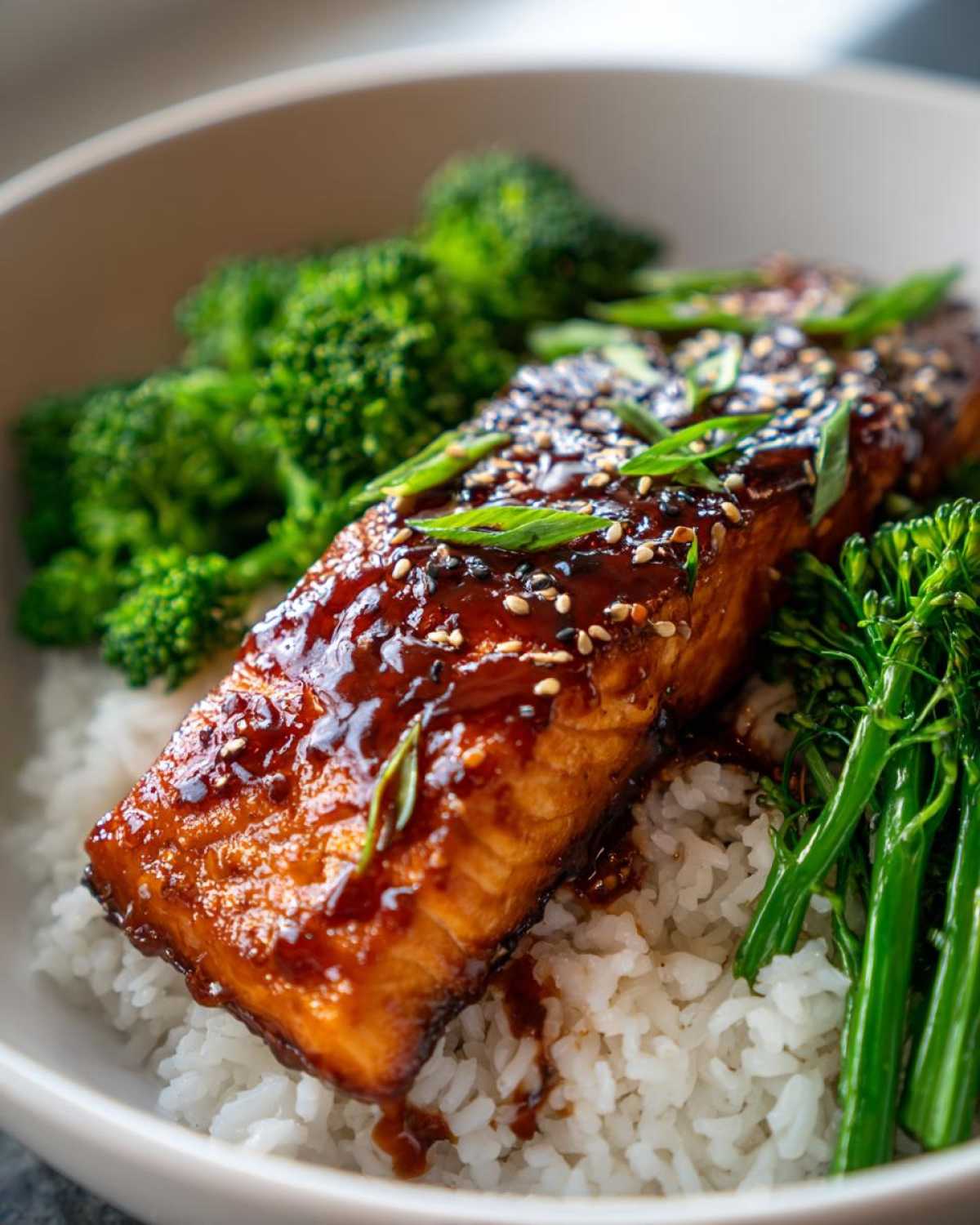 Close-up of a Teriyaki Salmon Rice Bowl featuring a glazed salmon fillet over white rice with steamed broccoli.