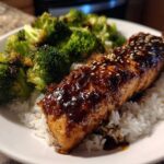 A close-up of a Teriyaki Salmon Rice Bowls serving featuring glazed salmon over white rice and roasted broccoli.
