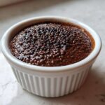 Close-up of thick Vegan Chocolate Chia Pudding texture in a white ribbed ramekin.
