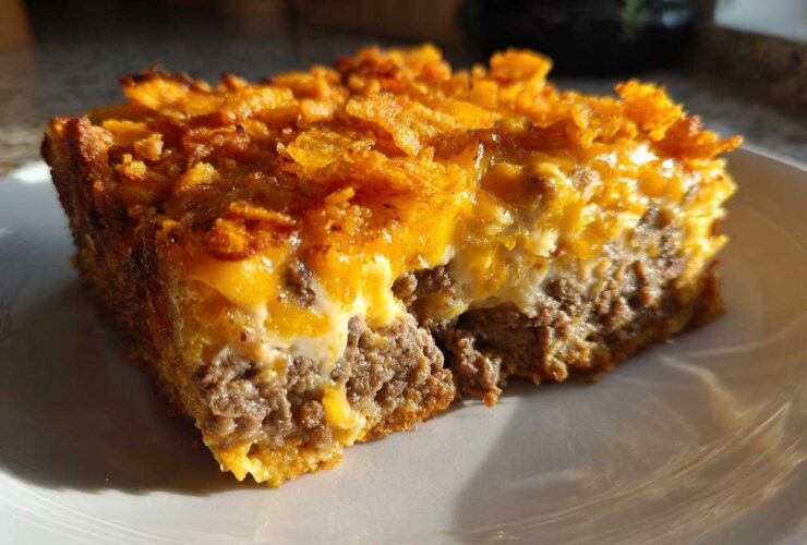 A close-up of a square serving of Cheesy Ground Beef Queso Bake Comfort Dish with a crunchy topping.