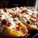 Close-up of baked Cheesy Ground Beef Stuffed Shells with rich meat filling and melted mozzarella cheese.