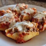 Close-up of baked Cheesy Ground Beef Stuffed Shells topped with melted mozzarella and marinara sauce.