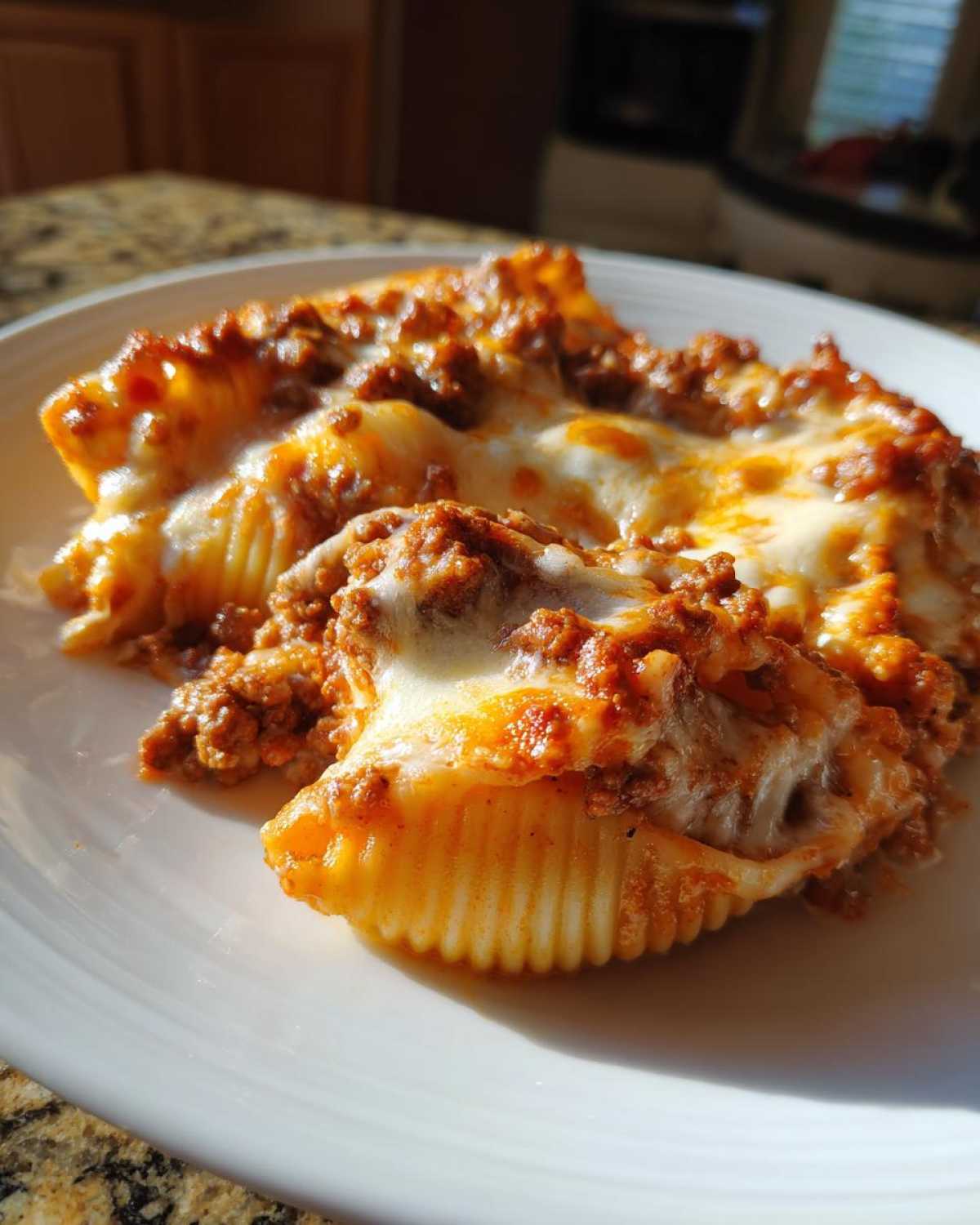 Close-up of baked Cheesy Pasta Shells with Creamy Beef Sauce, topped with melted mozzarella cheese.