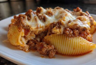 A close-up of baked Cheesy Pasta Shells with Creamy Beef Sauce, topped with melted mozzarella cheese.