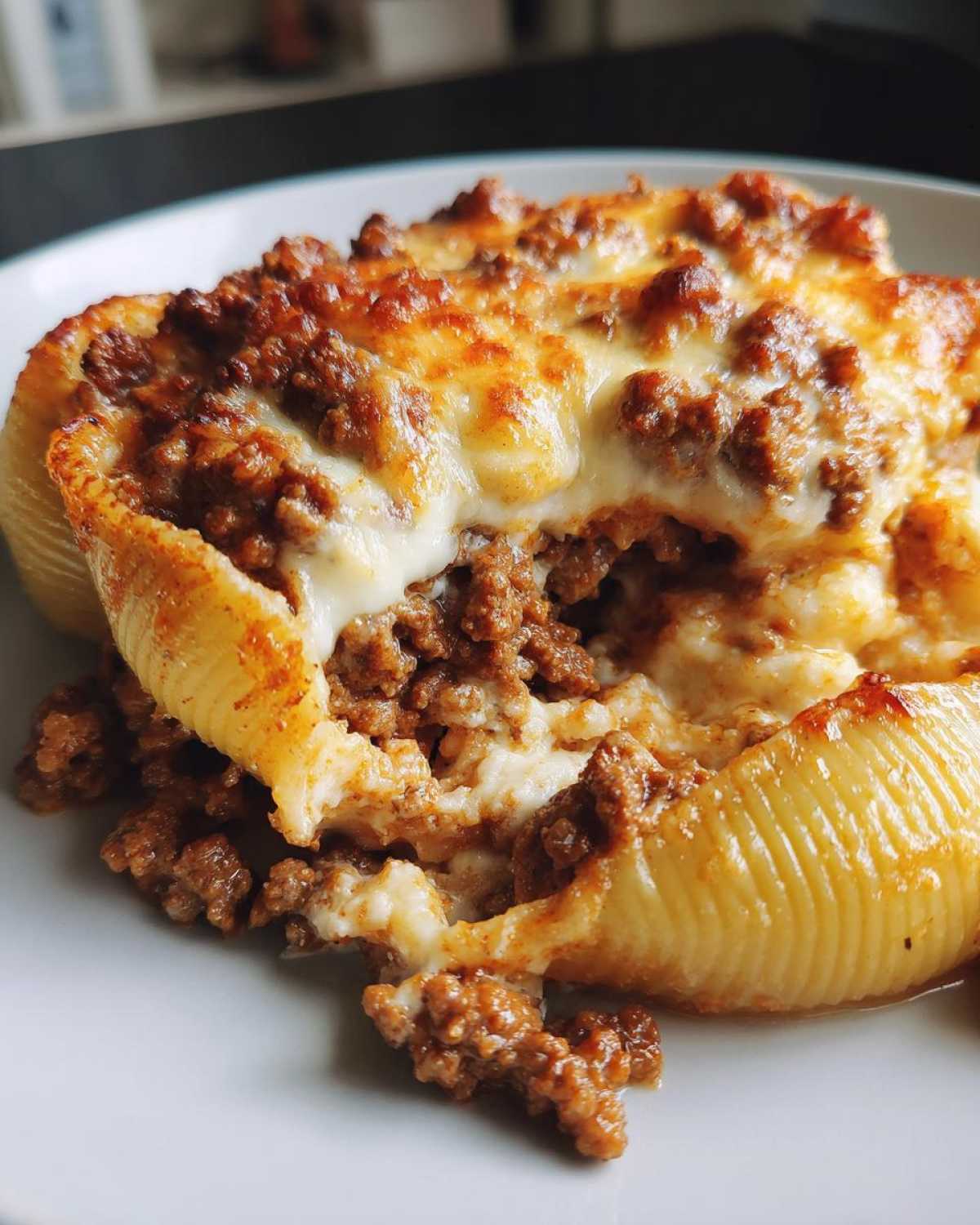 Close-up of baked Cheesy Pasta Shells with Creamy Beef Sauce, showing melted cheese and rich ground beef filling.