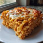 A close-up of a square serving of Creamy Cajun Chicken Alfredo Bake with a golden, melted cheese topping.