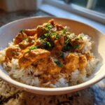 A bowl of Creamy Cajun Chicken Skillet with Rice topped with fresh parsley, lit by sunlight.