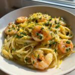 A bowl of Creamy Lemon Garlic Shrimp Pasta topped generously with bright lemon zest and fresh parsley.