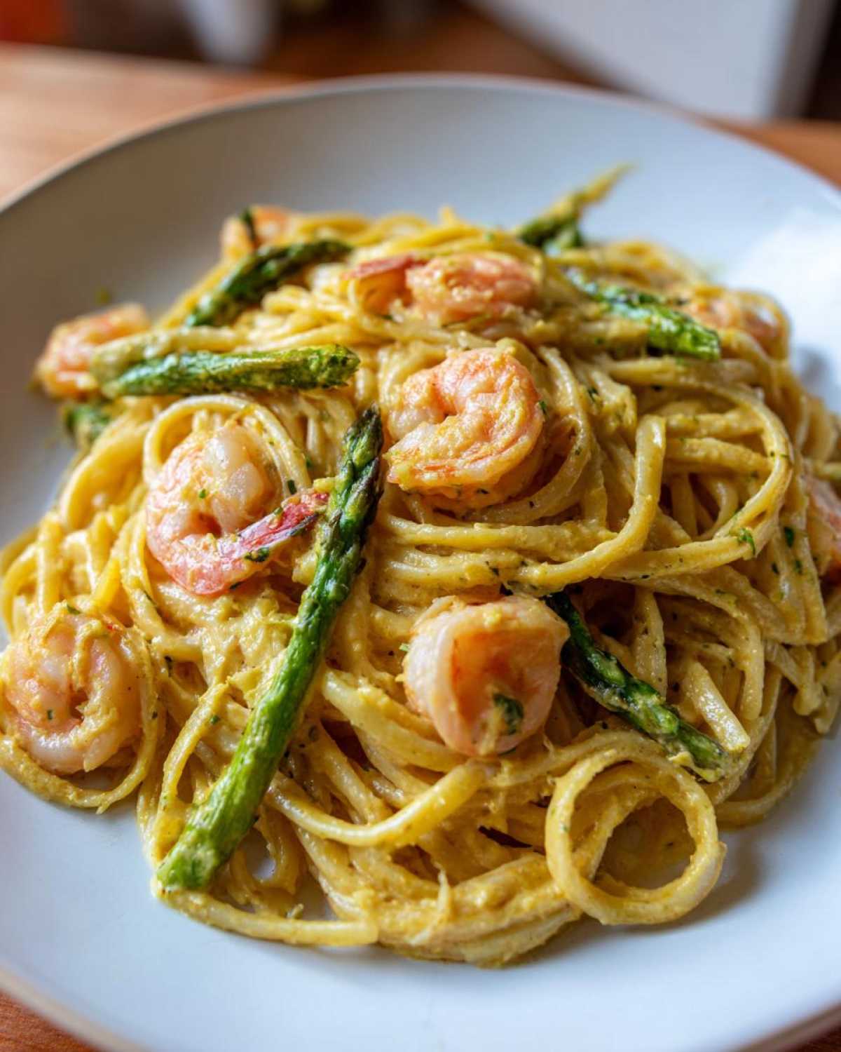 Close-up of Creamy Lemon Shrimp Pasta Fresh Flavor dish featuring linguine, pink shrimp, and bright green asparagus spears.