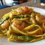 A close-up of Creamy Lemon Shrimp Pasta Fresh Flavor featuring pasta, pink shrimp, and bright green asparagus in a rich sauce.