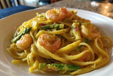A close-up of Creamy Lemon Shrimp Pasta Fresh Flavor featuring pasta, pink shrimp, and bright green asparagus in a rich sauce.