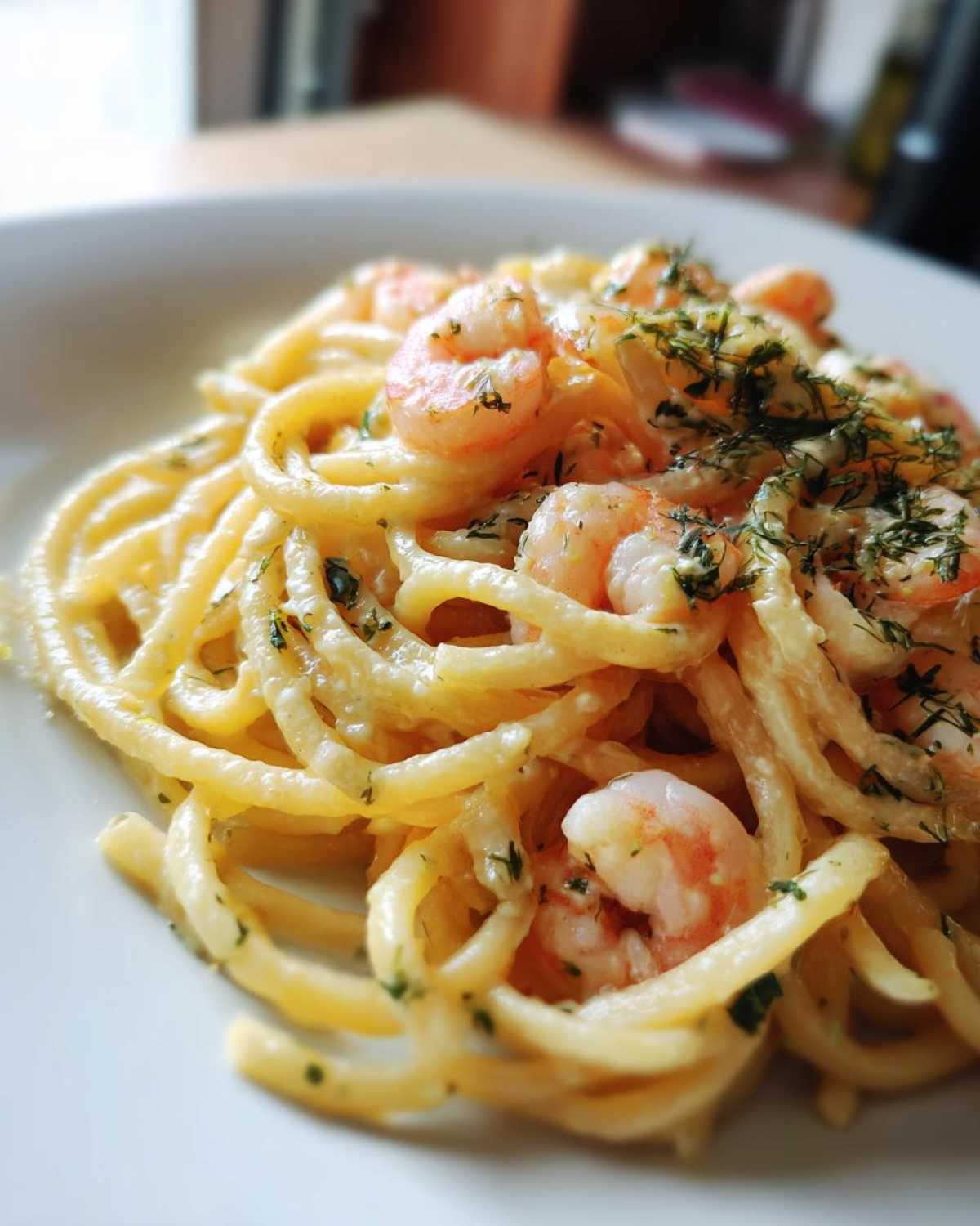 Close-up of Creamy Lemon Shrimp Pasta tossed in a rich sauce and topped with fresh dill.