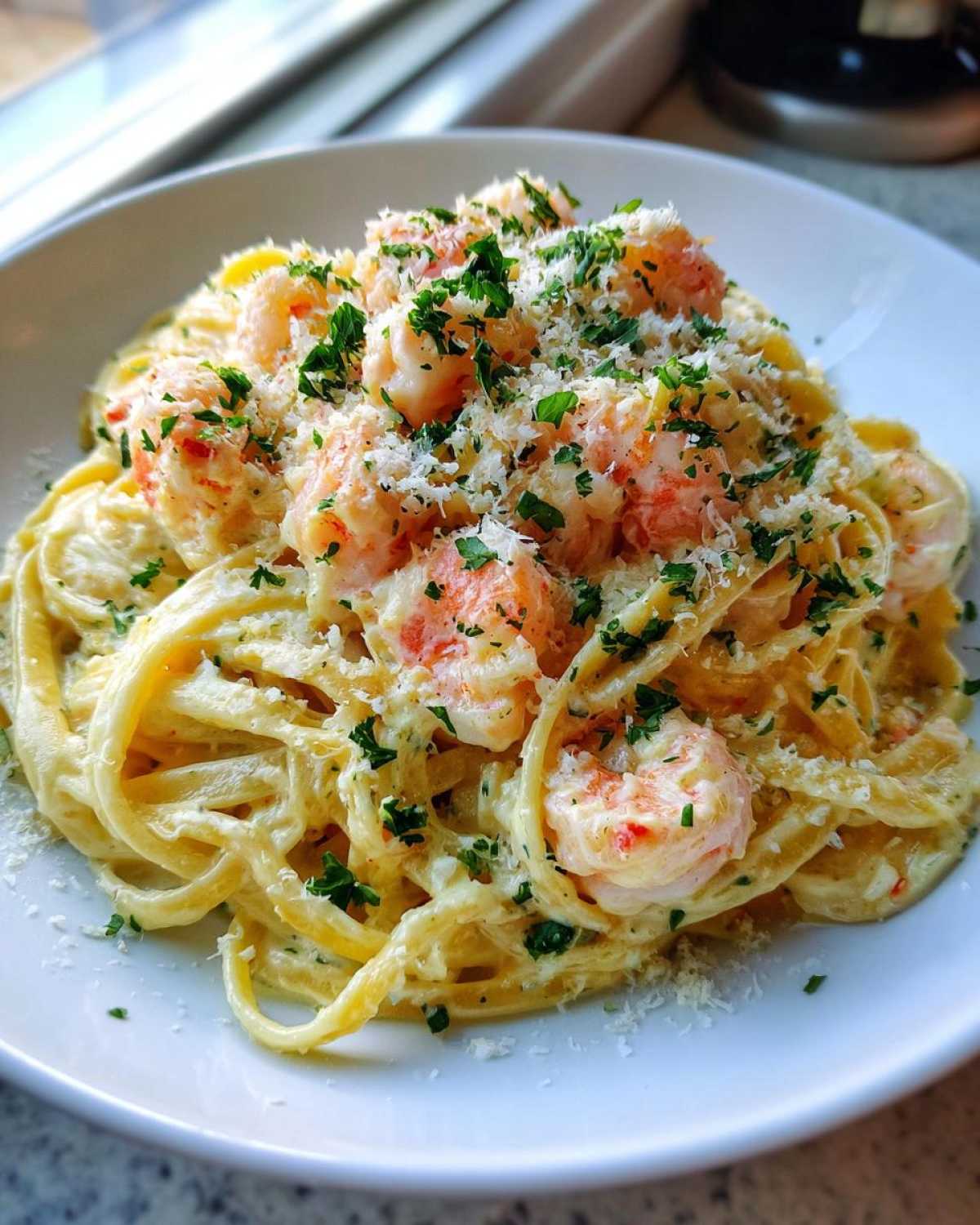A close-up of rich Creamy Lemon Shrimp Pasta with Garlic Sauce, topped generously with grated Parmesan and fresh parsley.
