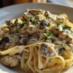 Close-up of rich Creamy Mushroom Garlic Pasta with Chicken tossed in a white sauce and garnished with parsley.