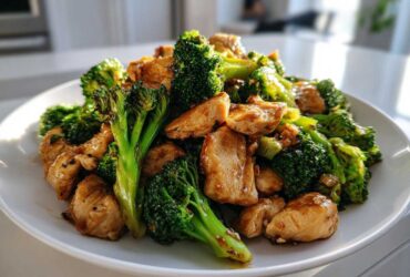 A close-up of Garlic Butter Chicken and Broccoli Stir Fry served on a white plate.