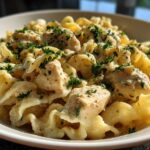 Close-up of Garlic Butter Chicken Pasta with cream sauce and chopped parsley garnish.