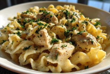 Close-up of Garlic Butter Chicken Pasta with cream sauce and chopped parsley garnish.