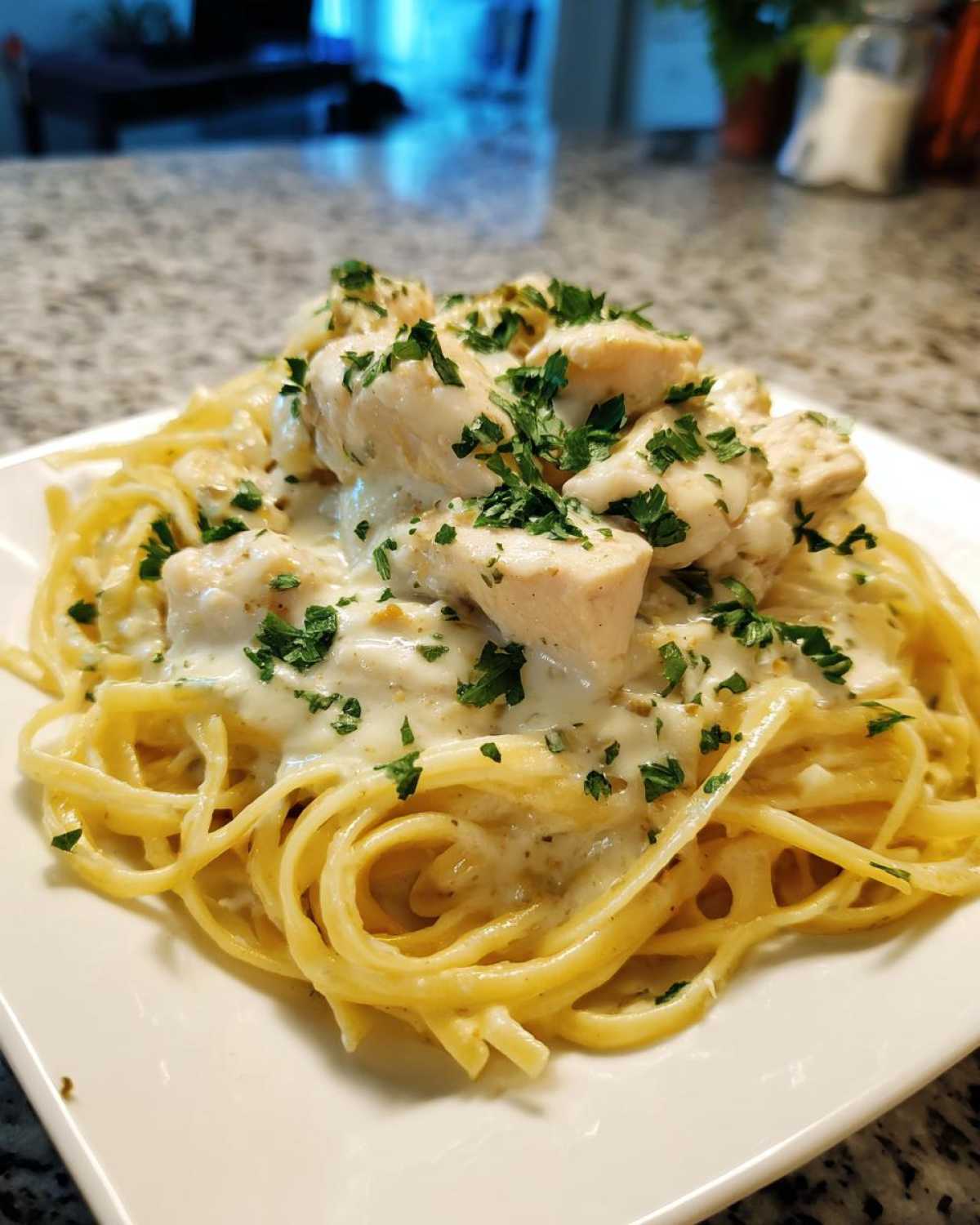 A close-up of Garlic Butter Chicken Pasta with Cream Sauce, topped with fresh parsley.