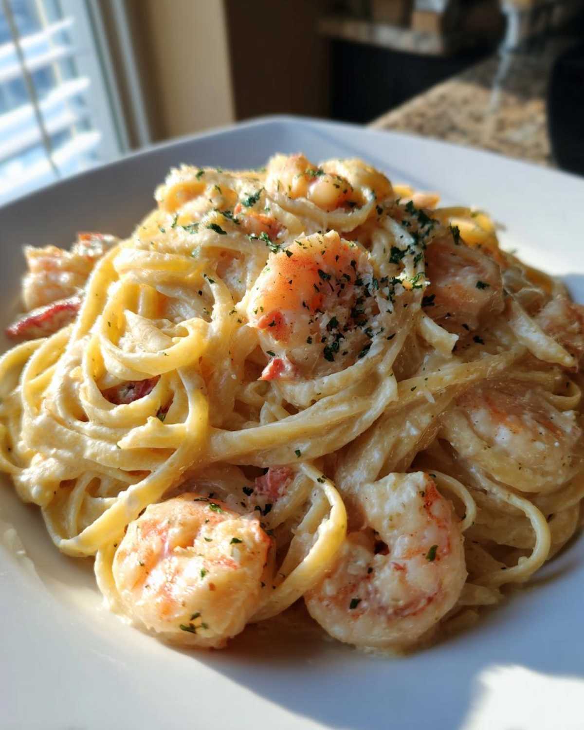 Close-up of creamy Garlic Butter Shrimp Pasta with fettuccine noodles and plump shrimp, garnished with parsley.