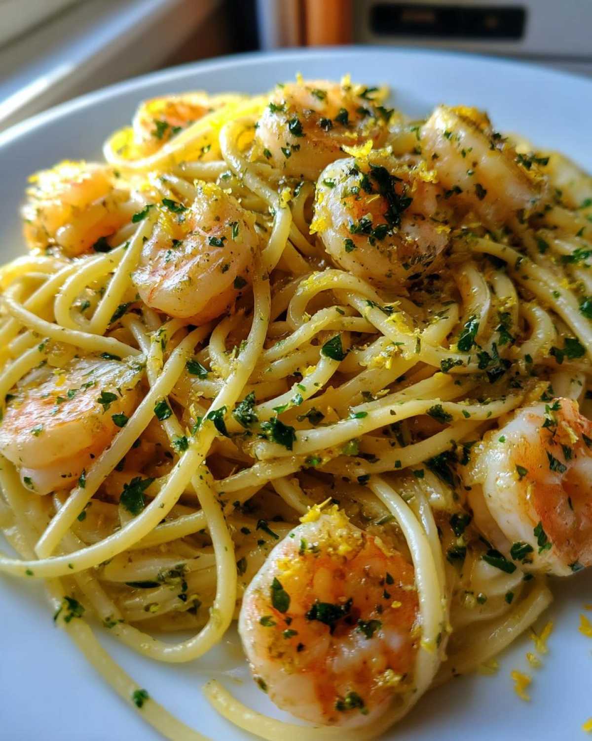 Close-up of a plate of Garlic Butter Shrimp Pasta with Lemon Flavor, topped with parsley and bright yellow lemon zest.