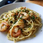 A close-up of a serving of Garlic Butter Shrimp Pasta with Lemon Flavor, topped with parsley and lemon zest.