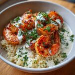 Close-up of a Garlic Butter Shrimp Rice Bowl featuring seared shrimp over rice, drizzled with white garlic sauce and fresh parsley.