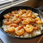 Close-up of Garlic Butter Shrimp with Rice Skillet, featuring seasoned shrimp over white rice in a black pan.