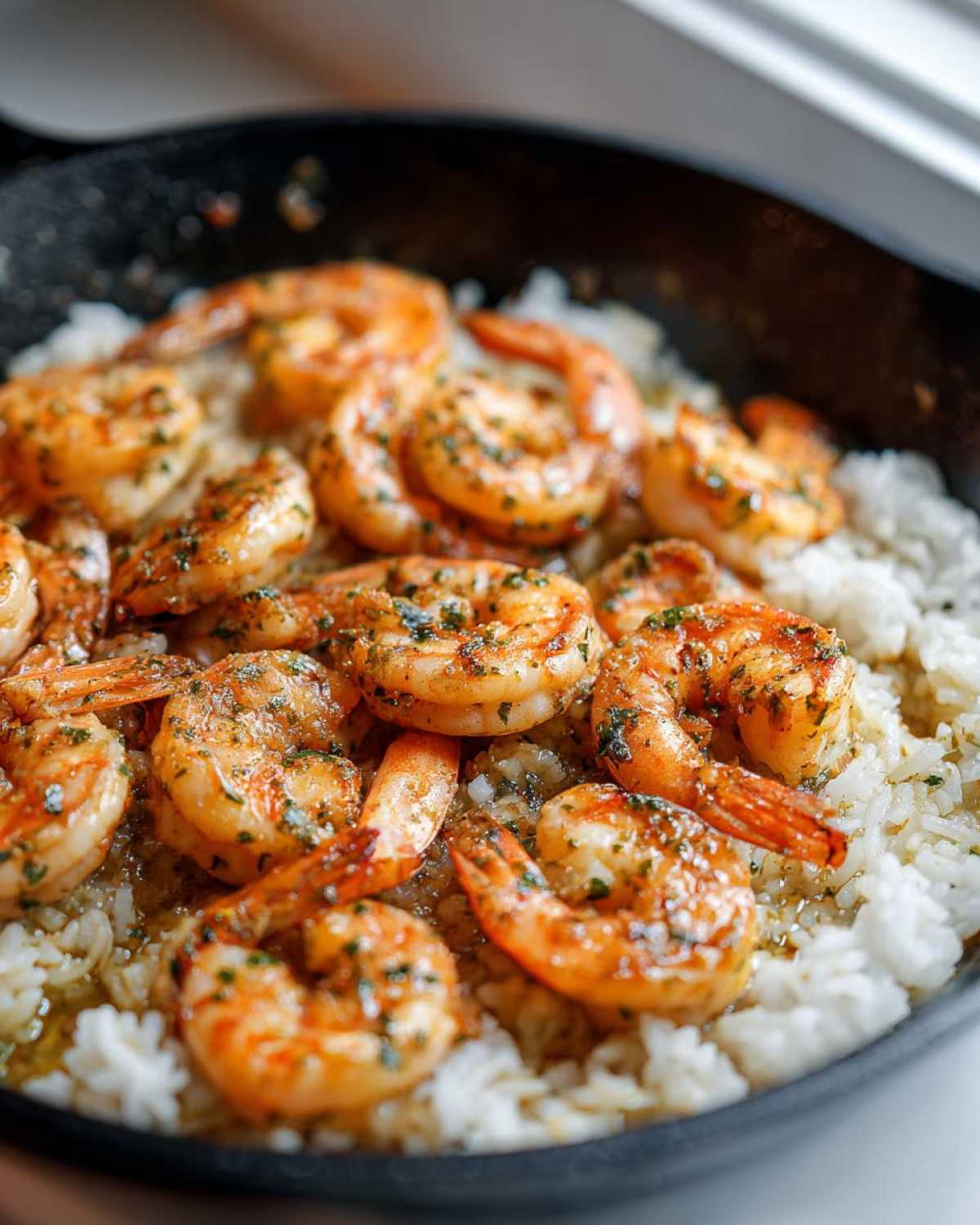 Close-up of succulent Garlic Butter Shrimp with Rice Skillet, topped with parsley.