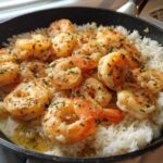 Plump, seasoned shrimp served over white rice in a black skillet, highlighting the Garlic Butter Shrimp with Rice Skillet.