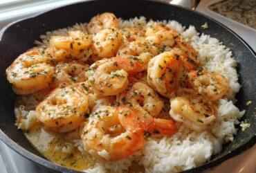 Plump, seasoned shrimp served over white rice in a black skillet, highlighting the Garlic Butter Shrimp with Rice Skillet.