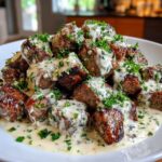 A mound of seared Garlic Butter Steak Bites generously covered in a creamy garlic sauce and fresh parsley.