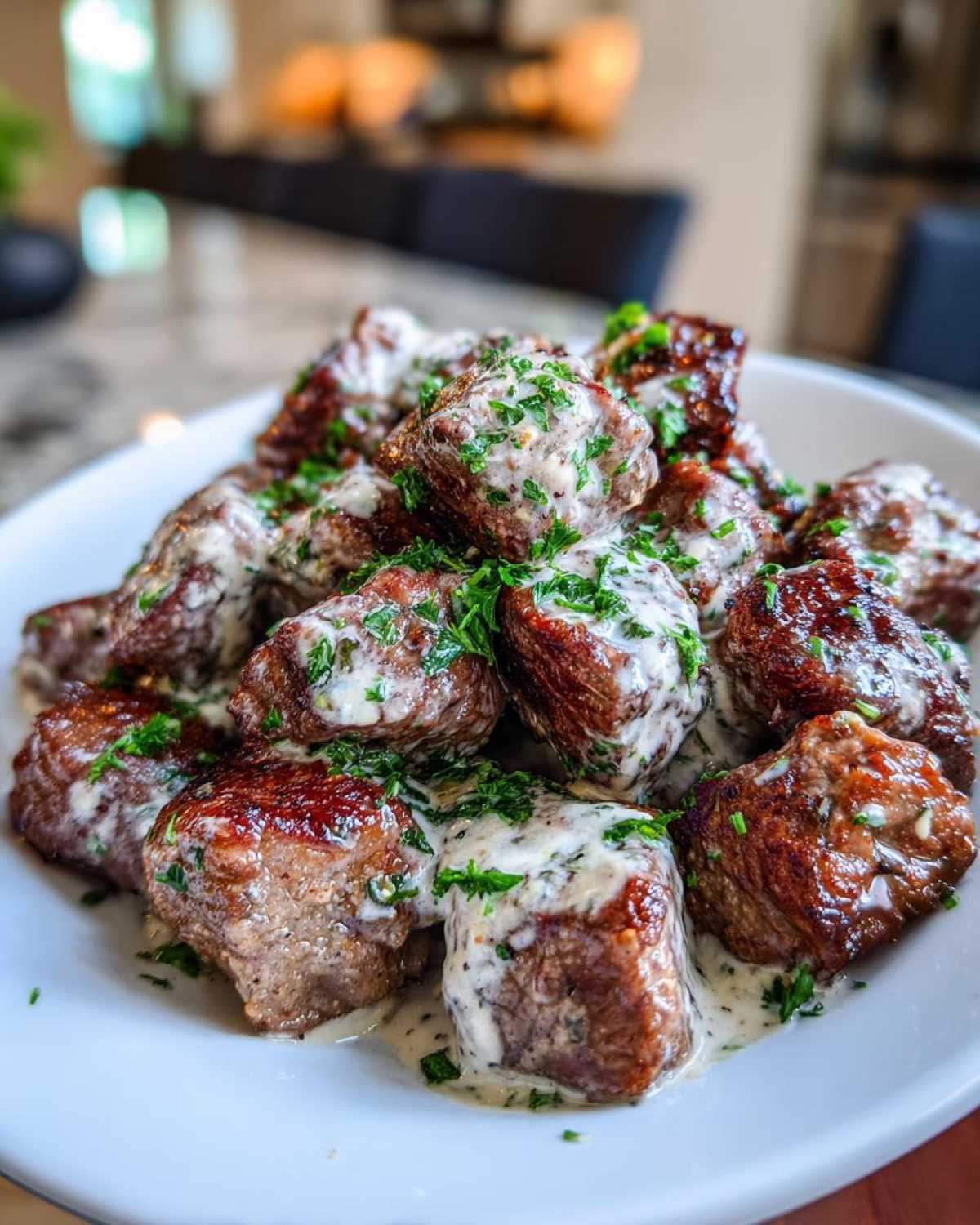 A mound of perfectly seared Garlic Butter Steak Bites smothered in a creamy garlic sauce and topped with fresh parsley.