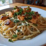 A white bowl filled with Honey Garlic Chicken Pasta with Cream Sauce, topped with seared chicken pieces and fresh parsley.