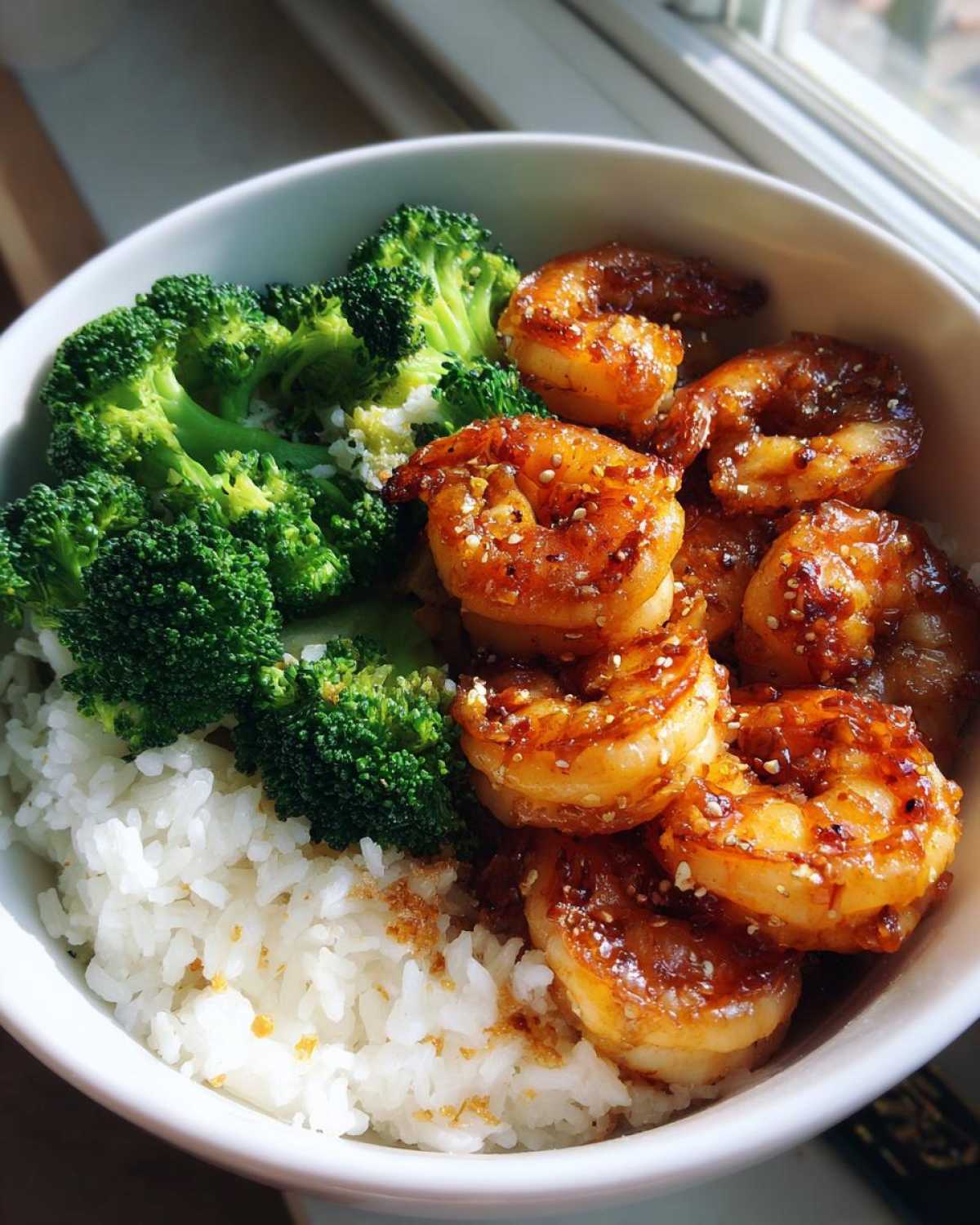 Close-up of a Honey Garlic Shrimp Bowl Quick Dinner featuring glazed shrimp, steamed broccoli, and white rice.