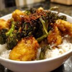 Close-up of a Honey Mustard Chicken Bowl with Rice, topped with crispy broccoli and fried onions.