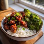 Close-up of a Honey Sriracha Chicken Bowl with glazed chicken, white rice, and steamed broccoli.