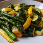 Close-up of sautéed Asparagus with Zucchini and Squash pieces seasoned with herbs.