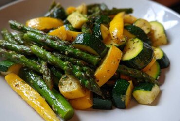 Close-up of sautéed Asparagus with Zucchini and Squash pieces seasoned with herbs.
