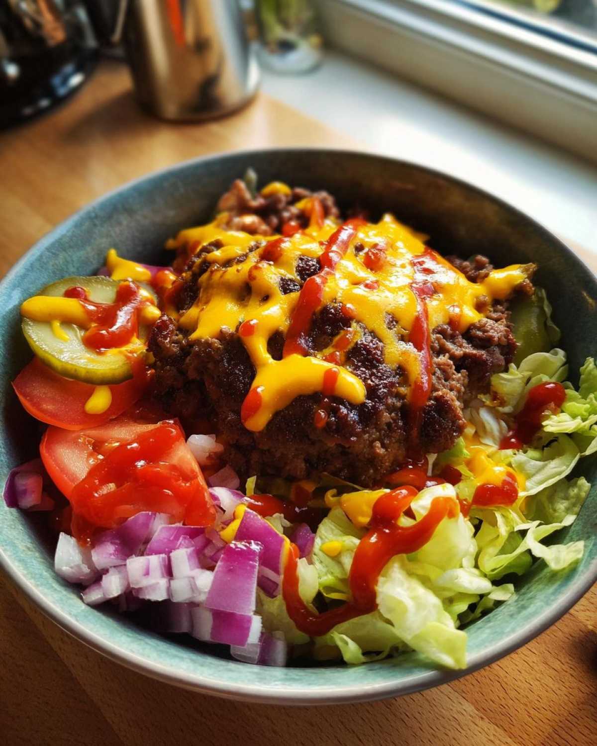 A close-up of a delicious Burger Bowls 30 Minute Dinner Idea featuring ground beef, melted cheese, lettuce, tomatoes, onions, and pickles.