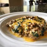 A serving of cheesy ground beef and spinach casserole, one of the Easy Keto Meals for Weight Loss, on a white plate.